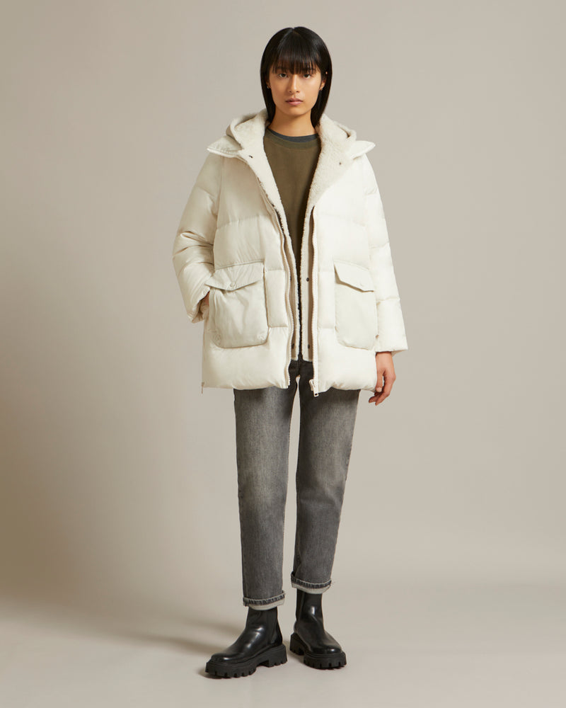 A line down jacket in a mix of technical fabrics with merino shearling hooded bib