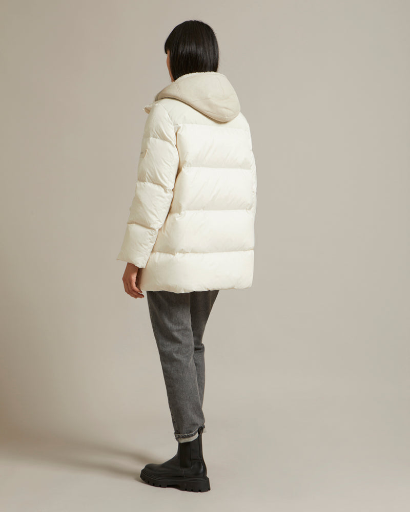 A line down jacket in a mix of technical fabrics with merino shearling hooded bib