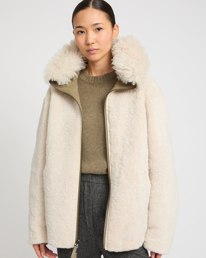 Revrsible hooded jacket in lambskin shearling and technical fabric