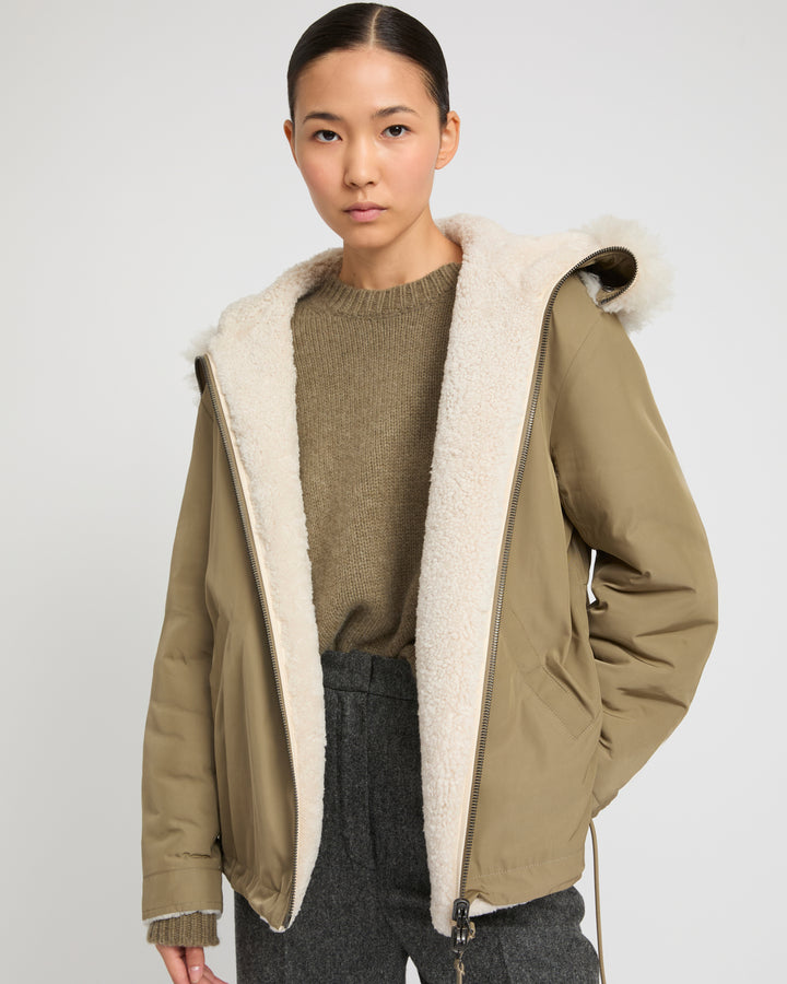 Revrsible hooded jacket in lambskin shearling and technical fabric